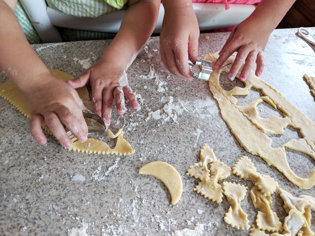 Toddler meal tips and ideas for fun kids food - two sisters making homemade pasta with cookie cutters
